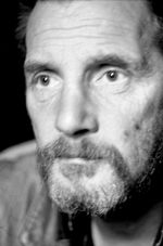 Camino inundado con reflejos del cielo nublado sobre el pavimento